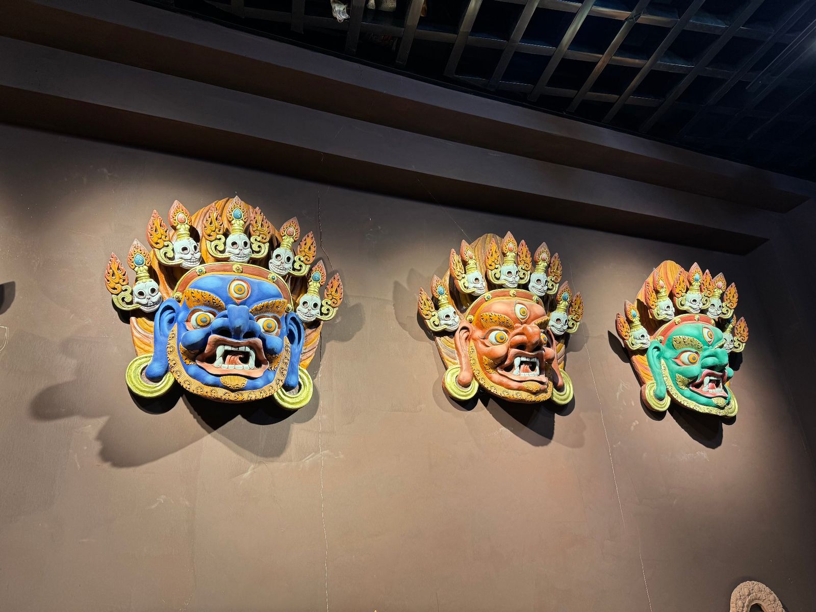 Three hand-painted medicine-clay wrathful-deity masks